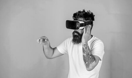 Man performing musical show in virtual reality simulation game. Bearded man with tattoo wearing VR headset. Man with hipster beard using digital touch screen interface, virtual reality concept.の写真素材