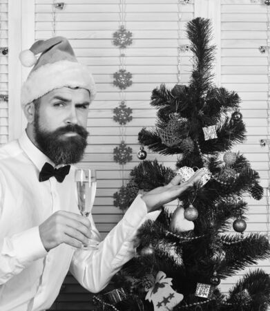 Man with beard holds champagne glass and shows fir treeの写真素材