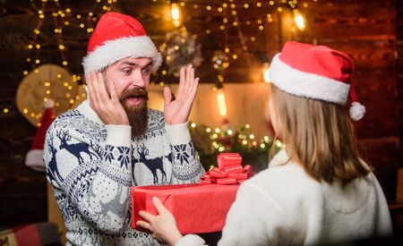 Generous Santa claus. Winter romance. Romantic feelings. Christmas time. Loving couple christmas tree background. Couple in love enjoy christmas holiday celebration. Family tradition. Surpriseの写真素材