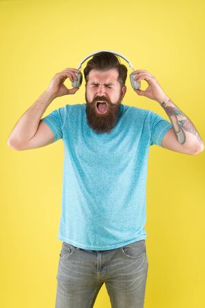 Modern music genre. Bearded man listen and sing to modern song. Modern hipster wear stylish...