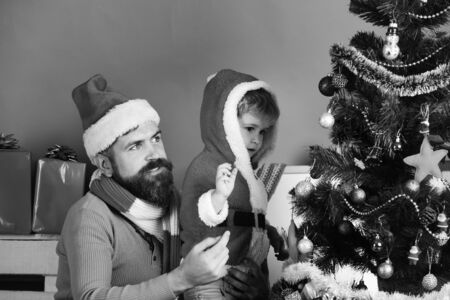 Boy and man with cheerful faces put ball on treeの写真素材