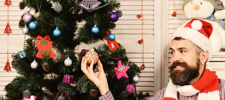 Guy decorates Christmas tree. Festivals and decor concept.の写真素材