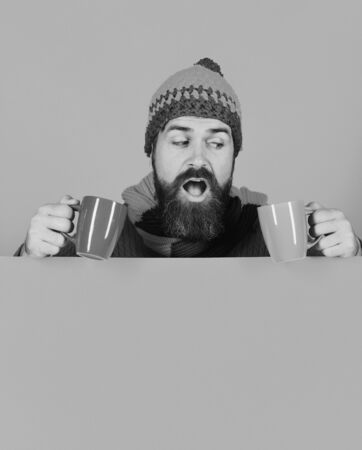 Man with beard holds brown and blue cups of medicine.の写真素材