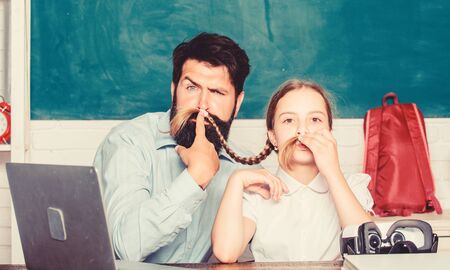 daughter study with father. Formal education. digital age with modern technology. study online. small child with bearded teacher man use laptop. innovative technology in modern school. back to schoolの写真素材