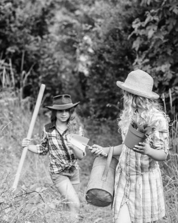 It is my favorite flower. children hold gardening tools. small girls farmer in village. farming agriculture. spring country side. earth day. summer family farm. ecology and environmental protectionの写真素材