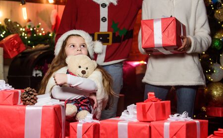 I wish. Happy family celebrate new year. Winter holidays. Shopping sales. small child and parents in santa hat. xmas gift boxes. Open present. merry christmas. Father and mother love daughterの写真素材