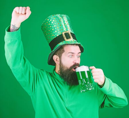 Bar seasonal holiday menu. Green beer mug. Cheers. Alcohol beverage. Lets start patricks party. Irish tradition. Man brutal bearded hipster drink pint beer. Irish pub. Drinking beer part celebrationの写真素材