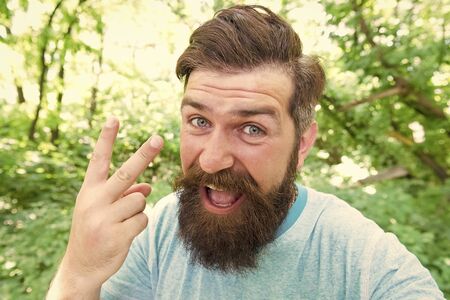 Brutal male leisure. Summer fun. Bearded guy in park forest. Bearded hipster. Hipster with long beard emotional face close up nature background. Crazy bearded mature man in natural environmentの写真素材