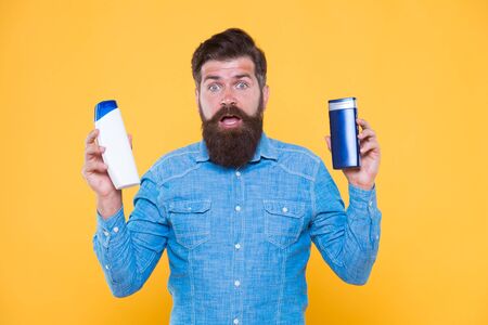 Perfect for modern man on go. Bearded man hold hair and body wash. Brutal man in casual style. Caucasian man with cosmetic products. Cosmetics and toiletries. Hygiene and health. For daily routineの写真素材