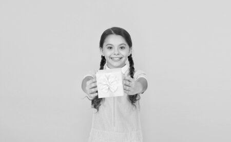 Happy birthday. Knowledge day. Schoolgirl giving gift to you. Generosity concept. Holiday celebration. Girl received gift. Tidy adorable pupil open gift box. Educational program for gifted kidsの写真素材