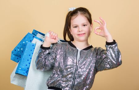 female shopping. Cheerful child. Little girl with gifts. Small girl with shopping bags. Sales and discounts. retail. Holiday purchase saving. Fashion and style. customer with package. little femaleの写真素材