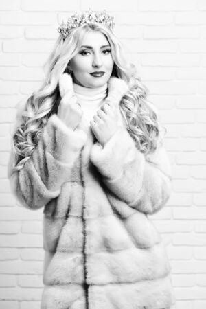 fashionable sexy woman in fur and fashion makeup, on brick wall studio backgroundの写真素材