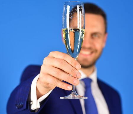 Managers hand holds glass of champagne in close up