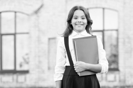 Learning language. Cute smiling child hold book. Little girl school student. Knowledge day. Hooked...