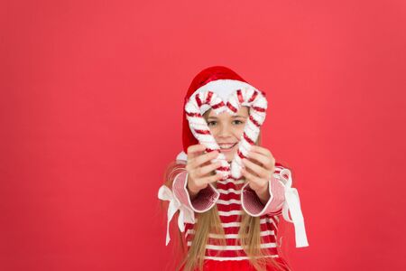 she ove party. xmas holiday decoration. christmas shopping time. happy new year celebration. festive party red color. sweet childhood happiness. small girl having fun. santa elf kid candy cane decorの写真素材