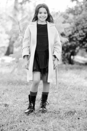 Fall bucket list. Child cheerful on fall walk. Warm coat best choice for autumn. Autumn season concept. Kid girl wear coat for autumn weather nature background. Fun activities for warm autumn daysの写真素材