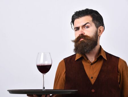 Guy with wine glass on tray. Man with confident face
