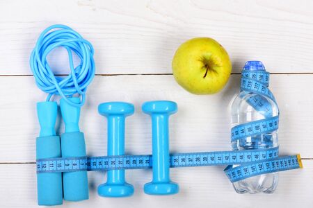 Centimeter tied around gym tools on white backdropの写真素材