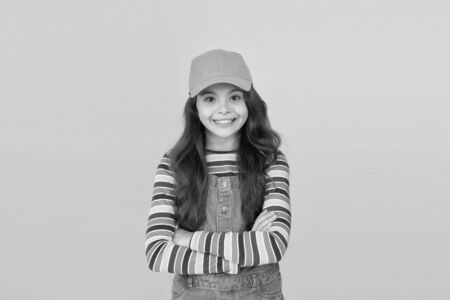 Trendy and fancy. Must have accessory. Modern fashion. Kids fashion. Summer sun protection cap. Girl long curly hair wear cap. Cute child wear cap or snapback hat. Little girl wearing baseball capの写真素材