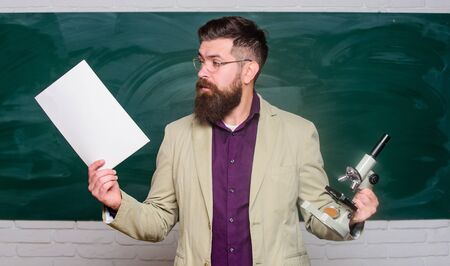 Teacher bearded man hold documents and microscope chalkboard background. Biology is his passion....