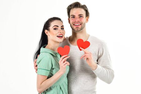 Valentines day and love. Romantic feelings concept. Man and woman couple in love hold red heart card on white background. Romantic couple in love hug. Handsome unshaven man and pretty girl in loveの写真素材