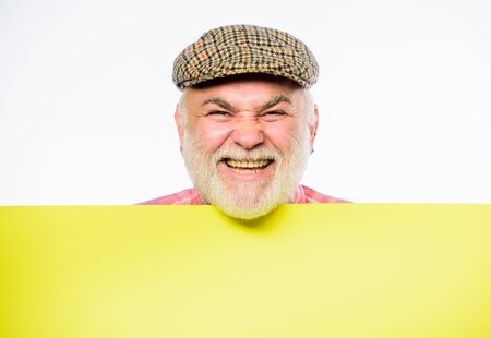 Announcement concept. Senior bearded emotional man peek out of banner place announcement. Event announcement. Pensioner grandfather in vintage hat poster information copy space. Elderly personの写真素材