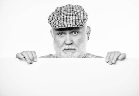 Copy space placate information. job search. Need help. Advertisement shop. Senior bearded man place announcement on banner. serious mature man in retro hat. Advertisementの写真素材