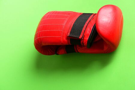 Training and fitness concept. Boxing gloves in red color. Pair of leather boxing sportswear. Sport equipment isolated on light green background.の写真素材