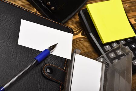 Calculator, hole punch, business card holder, note paper and pen. Leather covered notebook and...