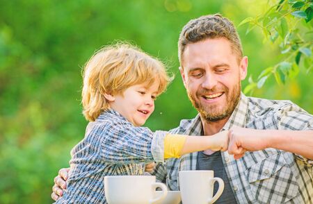Feed baby. Natural nutrition concept. Fathers day. Best friends. Father and son having fun. Feeding son natural foods. Healthy food. Father and boy drink tea outdoors. Develop healthy eating habitsの写真素材