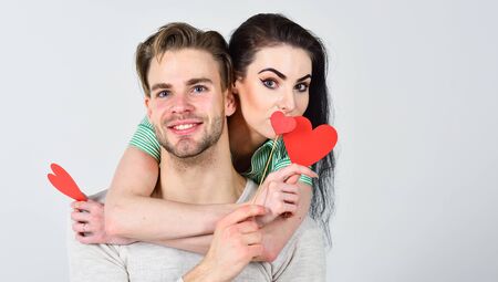 Man and woman couple in love hug and hold red heart valentines cards close up