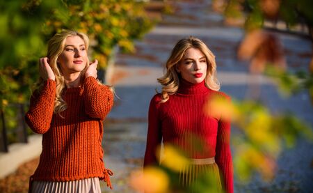 autumn park. Pleated trend. girls in corrugated skirt and sweater. female beauty. real femininity. autumn women outdoor. girl friends walk in park. sunny day with fallen leaves. fall fashion seasonの写真素材