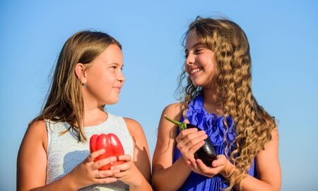 Kids hold vegetables sky background. Healthy homegrown food concept. Eat healthy. Summer harvest concept. Gmo free. Eco farming. Girls happy smiling child living healthy life. Healthy lifestyleの写真素材