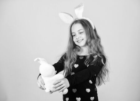 Child cute bunny costume. Kid hold tender soft rabbit toy. Easter day coming. Celebrate easter. Happy childhood. Easter activities for children. Holiday bunny little girl with long bunny earsの写真素材
