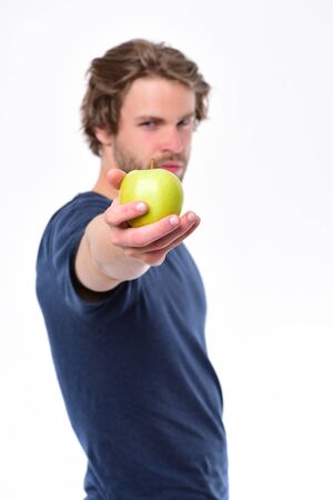 Man with bristle holds apple. Guy in blue tshirtの写真素材