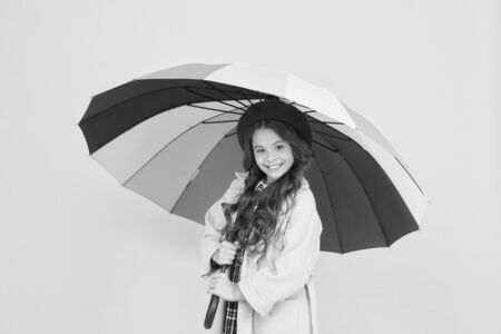 Bright umbrella. Have fun. Kid girl happy hold colorful rainbow umbrella. Rainy weather with proper garments. Positivity concept. Rainy day fun. Happy walk under umbrella. Enjoy rain conceptの写真素材