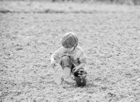 happy child gardener. spring country side village. earth day. soils and fertilizers. summer farm. small kid planting a flower. ecology environmental protection. farming and agriculture. Green lifeの写真素材