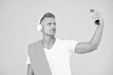 Selfie in gym concept. Sportsman smartphone and headphones. Healthy lifestyle. Gym aesthetics. Mature but still in good shape. Exercising in gym for better health. Man athlete taking selfie photoの写真素材