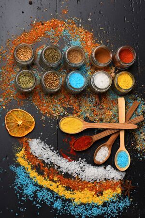 Wood spoons with paprika, turmeric and sea salt near citrus and spice mix on table. Food art...
