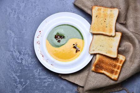 Spinach and pumpkin cream soup on grey texture background.の写真素材
