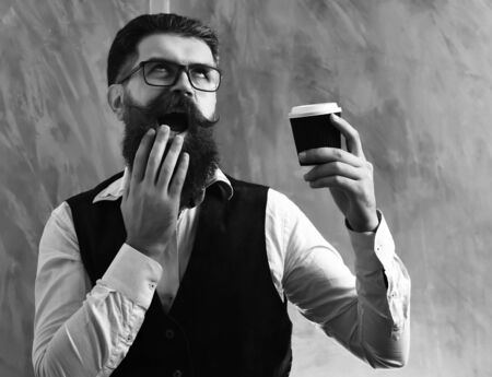 Bearded man, brutal caucasian hipster with moustache holding coffee cup