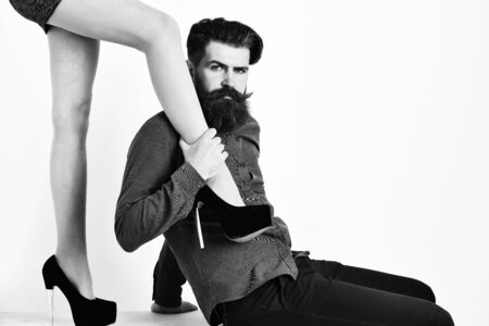 bearded man with sexy female legs has serious faceの写真素材
