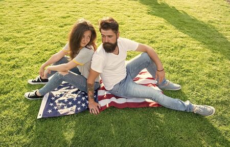 Independence day. National holiday. Bearded hipster and girl in love. 4th of July. American tradition. History of America. American patriotic people. American couple relaxing on USA flag outdoorsの写真素材
