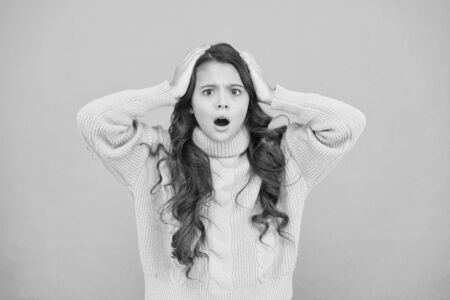 Kids psychology. Feeling surprised. Adorable surprised girl wear yellow sweater turquoise background. Surprise concept. Good vibes. Emotional baby. Surprised child. Positive attitude to lifeの写真素材