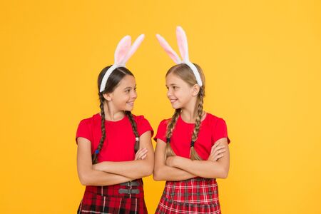 Easter traditional games. Bunny team. Entertainment and event concept. Spring holidays. Children in rabbit bunny ears. Family and sisterhood. Little schoolgirls school uniform with long bunny earsの写真素材