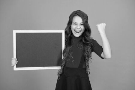 Awesome news. Educational program. School schedule information. School girl cute french student hold blackboard copy space. School announcement concept. Changes in school life. Success gestureの写真素材