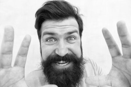 I am going catch you. Stylish beard and mustache care. Happy face. Beard fashion and barber. Handsome smiling guy close up. Masculinity concept. Man bearded hipster stylish beard grey backgroundの写真素材
