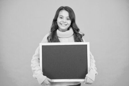 Product advertising. big sales advertising. happy small girl hold blackboard. best prices. useful info here. welcome on board. school girl on lesson. copy space for your textの写真素材