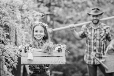 She knows everything about flowers. spring village country. father and daughter on ranch. little girl and happy man dad. earth day. ecology. Gardening tools. family farmの写真素材