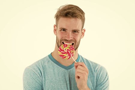 Guy eats giant colorful lollipop isolated whiteの写真素材